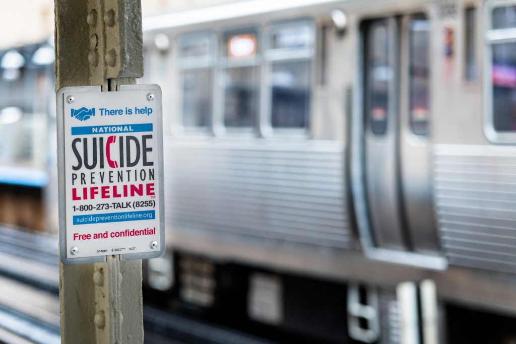 SUICIDE PREVENTION sign with hotline number in the subway station. 