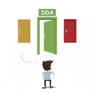 Man standing before three doors. The middle door has a sign that reads: DDA