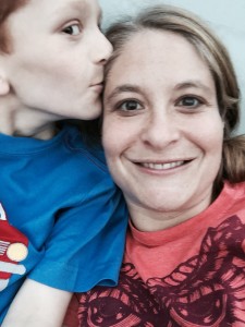 young son kissing mother on her forehead