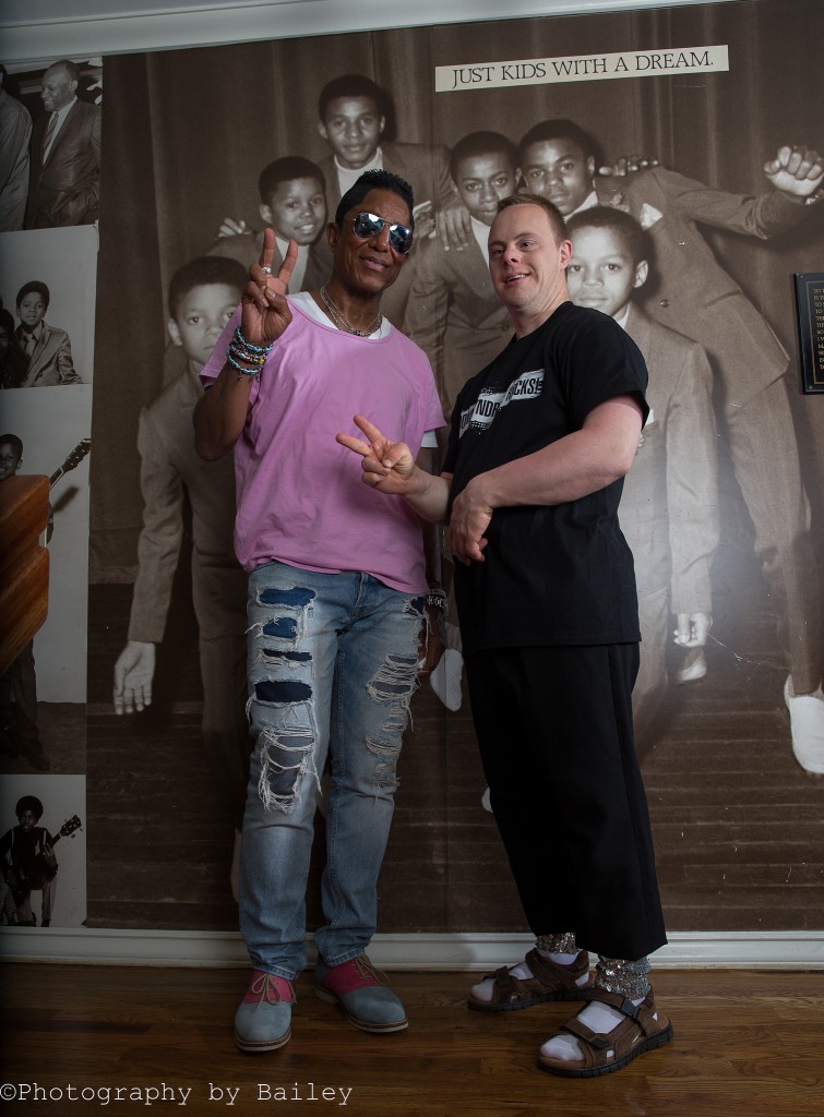 Jermaine Jackson poses with Dylan Kuehl in front of Jackson family portrait