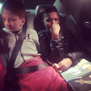 two boys in car, holding hands, friends