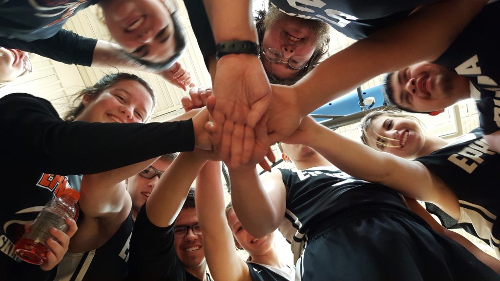 view from below of youth sports team in a huddle