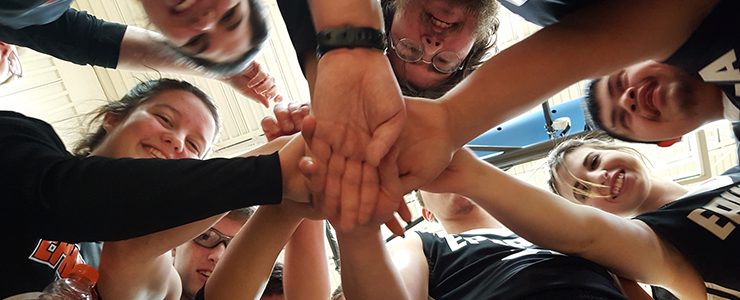 view from below of youth sports team in a huddle