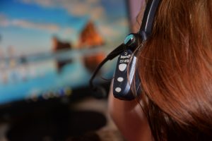 woman wearing wireless headset in front of computer screen