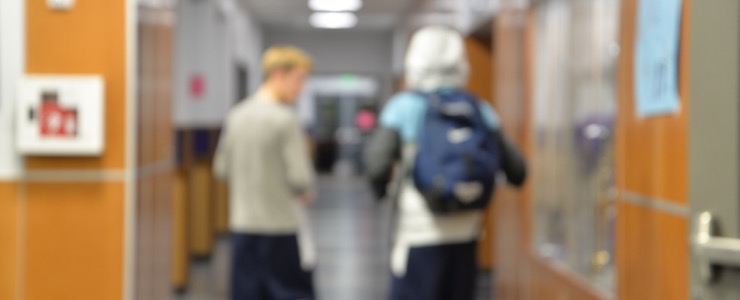 school hallway, two students walking,blurred