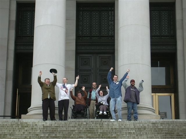 Disability advocates cheering on steps of state capitol building in Olympia, WA.