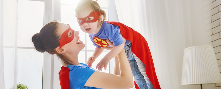 Mother and her child playing together. Girl and mom in Superhero costume. Mum and kid having fun, smiling and hugging. Family holiday and togetherness. (Mother and her child playing together. Girl and mom in Superhero costume. Mum and kid having fun,
