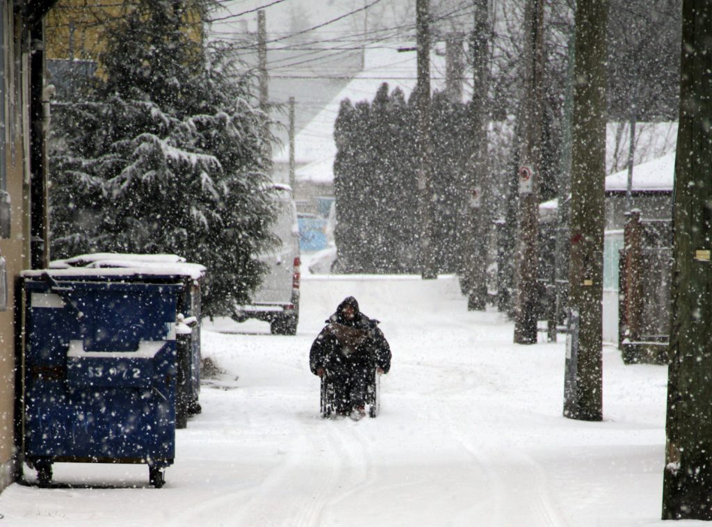 A man in a wheelchair during a Vancouver Snowstorm
