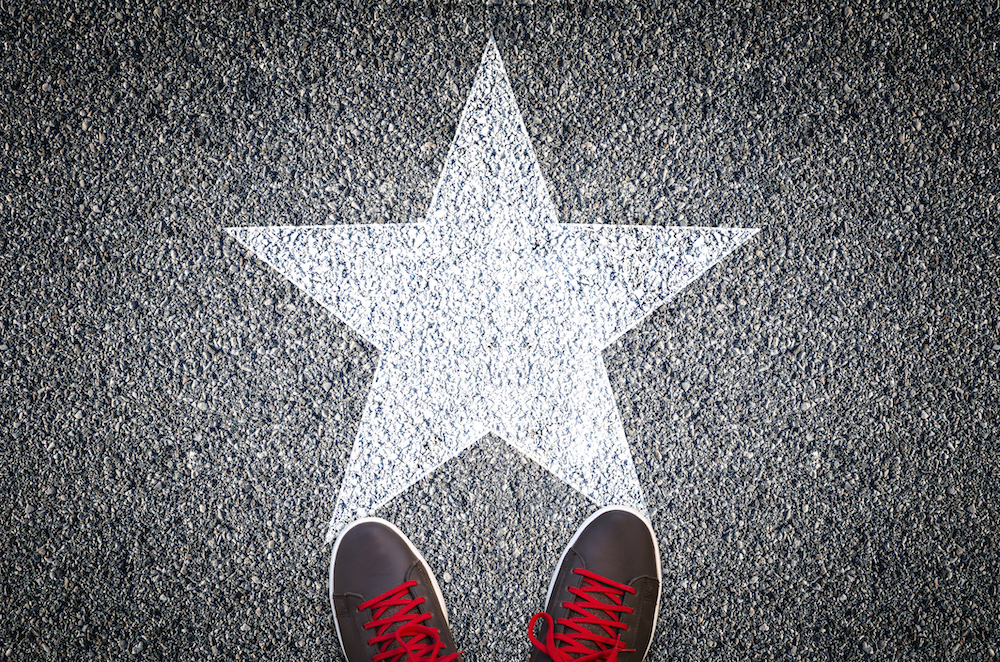 Sneakers on asphalt road with white star