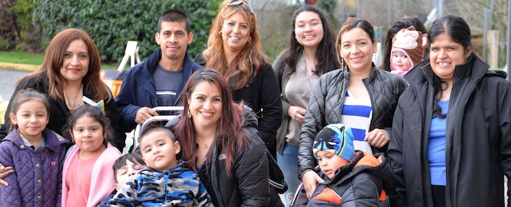 Multi generational Latino families taking a selfie outside.